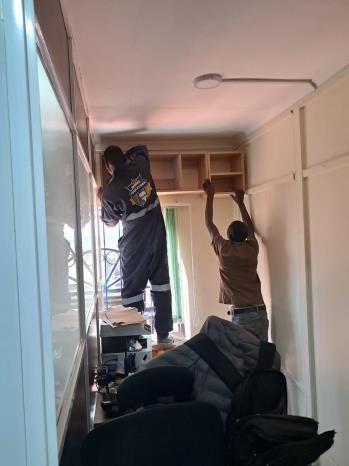 Overhead office cabinetry installation